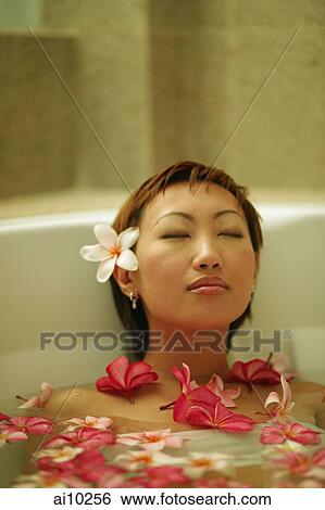 Woman relaxing in tub, flowers floating around her View Large Photo Image Stock Photograph - Woman relaxing in tub, flowers floating around her. Fotosearch