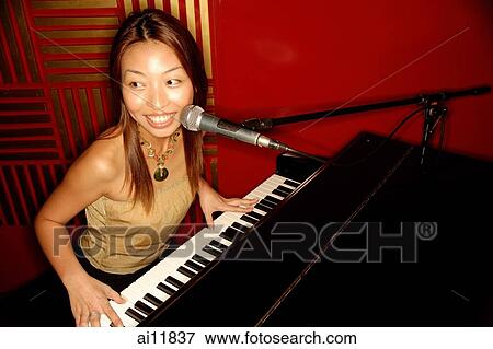 Woman singing and playing the piano View Large Photo Image Stock Photo - Woman singing and playing the piano. Fotosearch