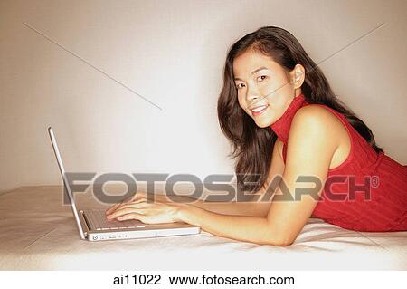 Woman using laptop, looking at camera View Large Photo Image Stock Image - Woman using laptop, looking at camera. Fotosearch
