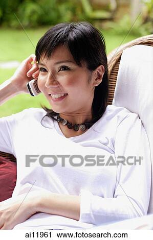 Woman using mobile phone, smiling View Large Photo Image Stock Image - Woman using mobile phone, smiling. Fotosearch