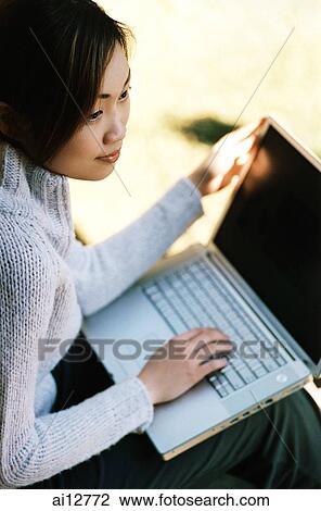 Woman with laptop on lap, looking away View Large Photo Image Stock Image - Woman with laptop on lap, looking away. Fotosearch