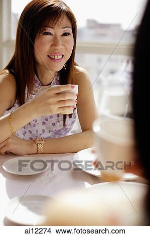 Woman with teacup facing another woman View Large Photo Image Picture - Woman with teacup facing another woman. Fotosearch
