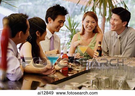 Young adults at bar counter having drinks View Large Photo Image Stock Photo - Young adults at bar counter having drinks. Fotosearch