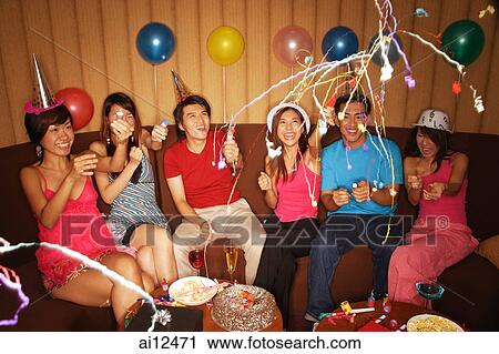 Young adults celebrating with crackers, party hats and balloons View Large Photo Image Stock Image - Young adults celebrating with crackers, party hats and balloons. Fotosearch