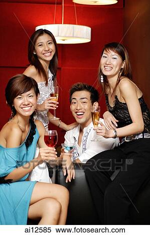 Young adults, holding drinks and smiling at camera View Large Photo Image Stock Photography - Young adults, holding drinks and smiling at camera. Fotosearch