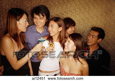 Young adults holding drinks, smiling and talking View Large Photo Image Stock Image - Young adults holding drinks, smiling and talking. Fotosearch