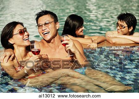 Stock Image - Young adults in swimming pool. Fotosearch