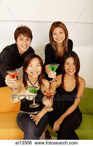 Young adults, looking at camera and holding cocktails View Large Photo Image Stock Photograph - Young adults, looking at camera and holding cocktails. Fotosearch