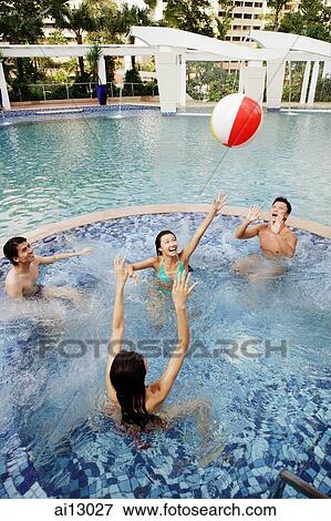 Young adults playing with inflatable ball in swimming pool View Large Photo Image Stock Photo - Young adults playing with inflatable ball in swimming pool. Fotosearch