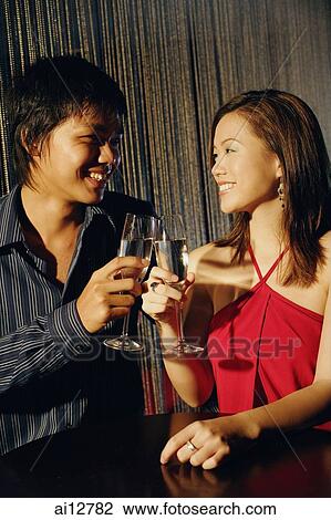 Young adults raising wine glasses, looking at each other View Large Photo Image Stock Image - Young adults raising wine glasses, looking at each other. Fotosearch