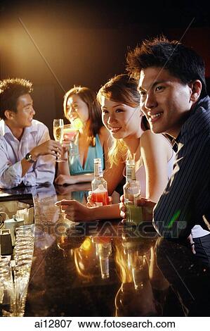 Young adults sitting at bar View Large Photo Image Stock Photo - Young adults sitting at bar. Fotosearch