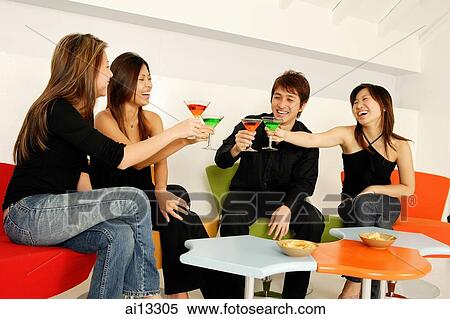 Young adults sitting in night club, toasting with cocktails View Large Photo Image Stock Photography - Young adults sitting in night club, toasting with cocktails. Fotosearch