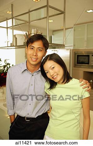 Young adults standing in kitchen, looking at camera View Large Photo Image Stock Image - Young adults standing in kitchen, looking at camera. Fotosearch
