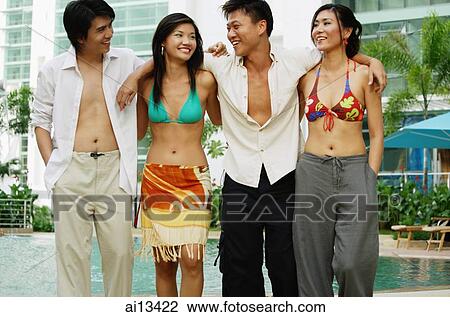 Young adults standing with arms around each other View Large Photo Image Stock Image - Young adults standing with arms around each other. Fotosearch