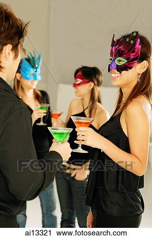 Young adults wearing masks, standing and holding drinks View Large Photo Image Stock Image - Young adults wearing masks, standing and holding drinks. Fotosearch