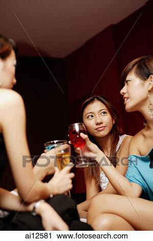 Young adults with drinks, low angle view View Large Photo Image Stock Image - Young adults with drinks, low angle view. Fotosearch