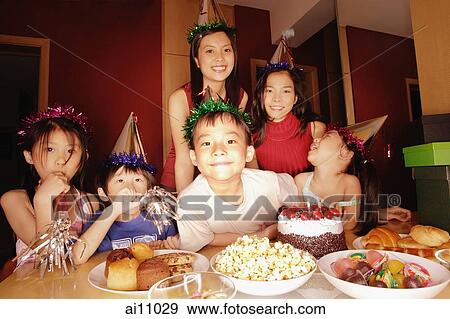 Young boy at a birthday party, surrounded by friends View Large Photo Image Stock Photo - Young boy at a birthday party, surrounded by friends. Fotosearch