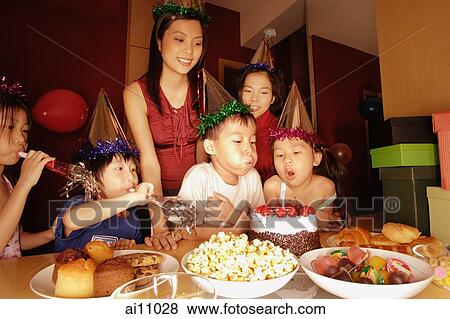 Young boy blowing out candles on a cake View Large Photo Image Stock Photo - Young boy blowing out candles on a cake. Fotosearch