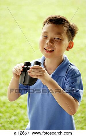 Young boy holding binoculars, smiling View Large Photo Image Stock Photo - Young boy holding binoculars, smiling. Fotosearch