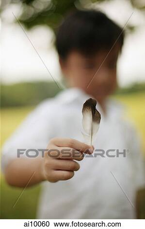 Young boy holding feather View Large Photo Image Stock Image - Young boy holding feather. Fotosearch
