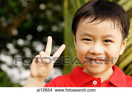 Young boy looking at camera, making peace sign View Large Photo Image Picture - Young boy looking at camera, making peace sign. Fotosearch