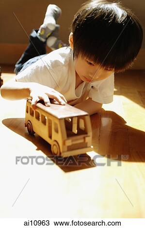 Young boy playing with toy bus View Large Photo Image Stock Image - Young boy playing with toy bus. Fotosearch