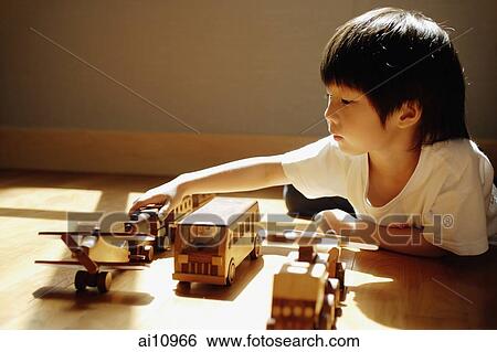 Young boy playing with toys, side view View Large Photo Image Stock Photograph - Young boy playing with toys, side view. Fotosearch