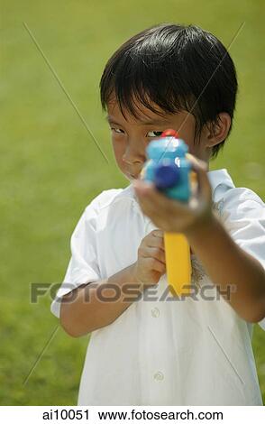 Young boy playing with water gun View Large Photo Image Stock Image - Young boy playing with water gun. Fotosearch