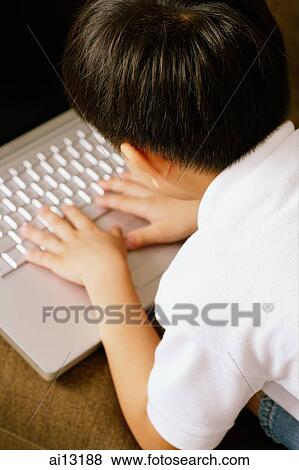 Young boy using laptop View Large Photo Image Stock Photo - Young boy using laptop. Fotosearch