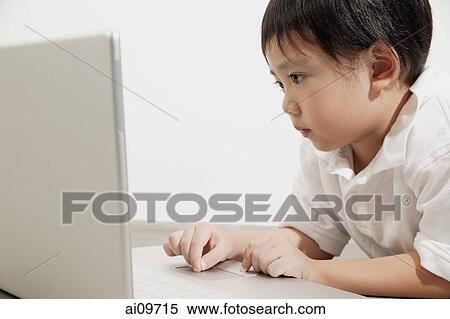 Young boy using laptop View Large Photo Image Stock Photography - Young boy using laptop. Fotosearch