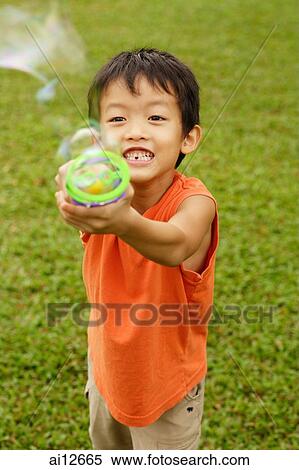 Young boy with bubble blower toy View Large Photo Image Stock Photography - Young boy with bubble blower toy. Fotosearch