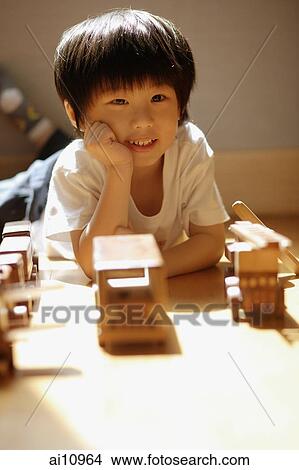 Young boy with hands on chin, looking at camera View Large Photo Image Picture - Young boy with hands on chin, looking at camera. Fotosearch