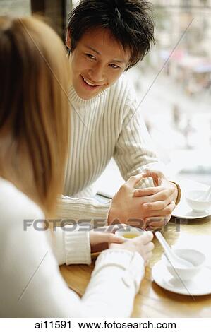 Young couple at a restaurant, talking, face to face View Large Photo Image Stock Image - Young couple at a restaurant, talking, face to face. Fotosearch
