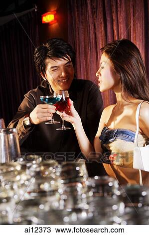 Young couple having drinks at night club View Large Photo Image Stock Image - Young couple having drinks at night club. Fotosearch