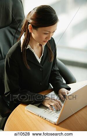 Young executive sitting, using laptop View Large Photo Image Stock Photo - Young executive sitting, using laptop. Fotosearch