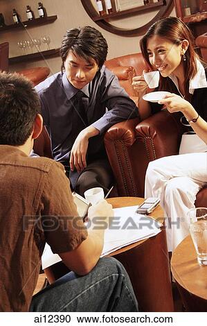 Young executives having a meeting in a cafe, woman drinking coffee View Large Photo Image Stock Image - Young executives having a meeting in a cafe, woman drinking coffee. Fotosearch