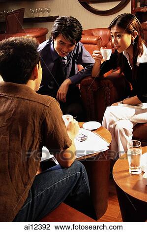 Young executives having a meeting in a cafe, woman holding cup View Large Photo Image Stock Image - Young executives having a meeting in a cafe, woman holding cup. Fotosearch