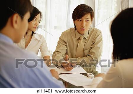 Young executives sitting face to face, having a meeting View Large Photo Image Stock Image - Young executives sitting face to face, having a meeting. Fotosearch