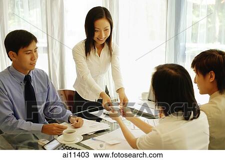 Young female executive giving her business card to colleagues. View Large Photo Image Stock Image - Young female executive giving her business card to colleagues.. Fotosearch