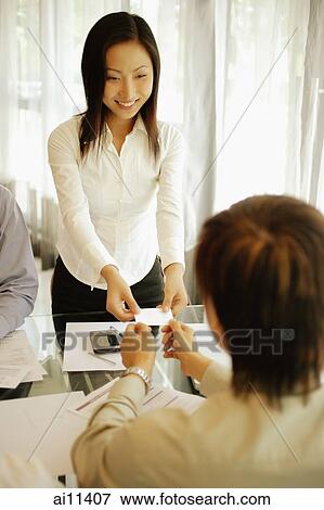Young female executive giving her business card to male executive View Large Photo Image Stock Photo - Young female executive giving her business card to male executive. Fotosearch