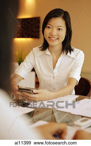 Young female executive smiling, another female in front of her. View Large Photo Image Stock Photo - Young female executive smiling, another female in front of her.. Fotosearch