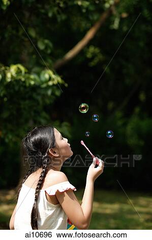 Young girl blowing bubbles. View Large Photo Image Stock Photograph - Young girl blowing bubbles.. Fotosearch
