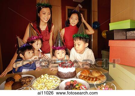 Young girl blowing out candles at a birthday party. View Large Photo Image Stock Photograph - Young girl blowing out candles at a birthday party.. Fotosearch