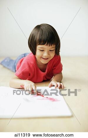 Young girl drawing on drawing pad, lying on front View Large Photo Image Stock Photo - Young girl drawing on drawing pad, lying on front. Fotosearch