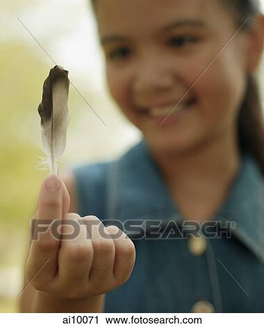 Young girl holding a feather View Large Photo Image Stock Image - Young girl holding a feather. Fotosearch