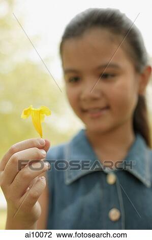 Young girl holding a flower View Large Photo Image Stock Image - Young girl holding a flower. Fotosearch