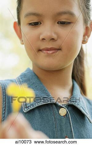 Young girl holding a flower View Large Photo Image Stock Image - Young girl holding a flower. Fotosearch
