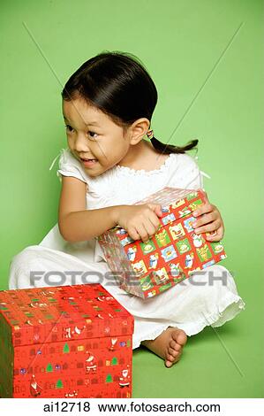 Stock Photo - Young girl holding gift wrapped box. Fotosearch