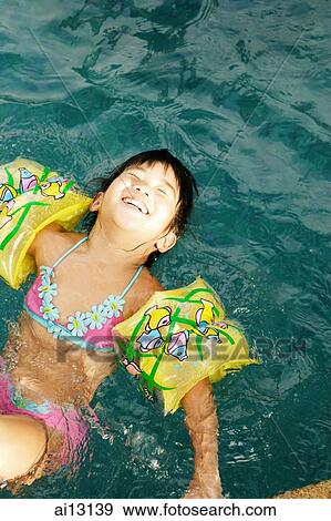 Young girl in swimming pool with arm bands, eyes closed View Large Photo Image Stock Photo - Young girl in swimming pool with arm bands, eyes closed. Fotosearch