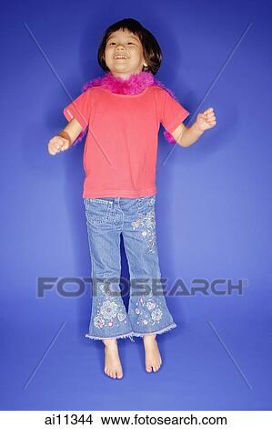 Young girl jumping, blue background View Large Photo Image Picture - Young girl jumping, blue background. Fotosearch